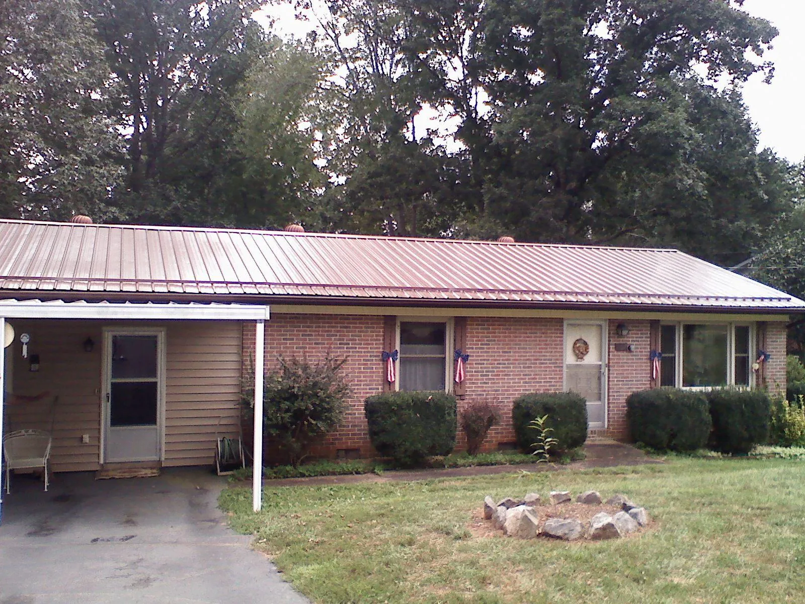 Bronze metal roof and carport on a brick ranch home — Roof Repair work by our crew in Nineveh